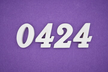 The numbers are made of white painted wood, placed on a purple paper background.