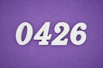 The numbers are made of white painted wood, placed on a purple paper background.
