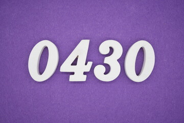 The numbers are made of white painted wood, placed on a purple paper background.