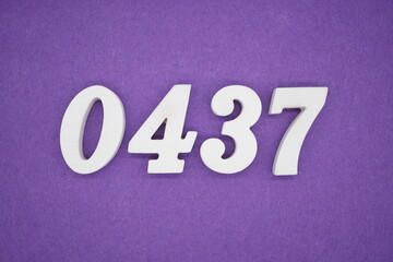 The numbers are made of white painted wood, placed on a purple paper background.