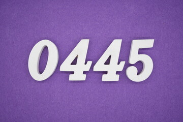 The numbers are made of white painted wood, placed on a purple paper background.
