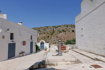 A narrow street among the white houses of Ginosa, an Apulian village, Italy.
