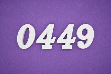 The numbers are made of white painted wood, placed on a purple paper background.