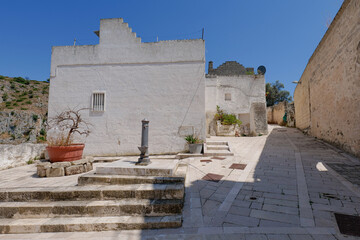 A narrow street among the white houses of Ginosa, an Apulian village, Italy.