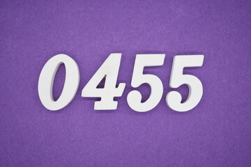The numbers are made of white painted wood, placed on a purple paper background.