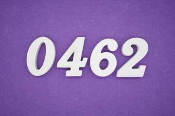 The numbers are made of white painted wood, placed on a purple paper background.