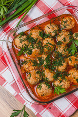 Meatballs in tomato sauce in a baking dish with herbs