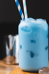 Milk is added to a glass of blue tea
