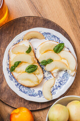 Bruschetta with ricotta and nectarines, garnished with honey and basil
