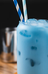 Milk is added to a glass of blue tea