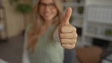 Woman raising thumb up then thumb down in office to show positive and negative feedback; approval...