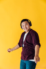 Asian man dancing to music in headphones