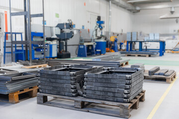 Industrial factory interior with machinery and metal frames on pallets