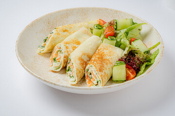 Delight in rolled crepes filled with savory ingredients, garnished with a vibrant salad