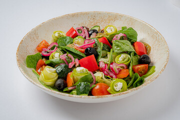 Vibrant salad with fresh greens, tomatoes, and olives in a rustic bowl