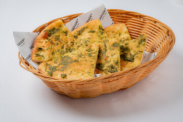 A warm basket filled with aromatic garlic bread topped with flavorful herbs, perfect for sharing