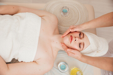 Massage therapist doing medical facial massage to woman