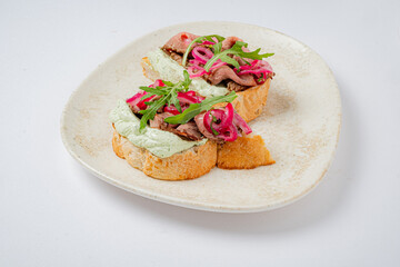 Tasty open-faced sandwich topped with fresh greens and pickled onions