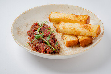 Enjoy rich beef tartare with perfectly toasted breadsticks, beautifully presented