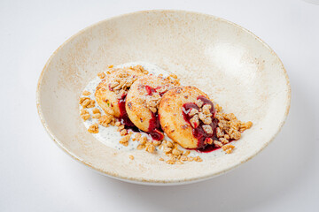 Three dessert bites on creamy yogurt, topped with berry sauce and granola