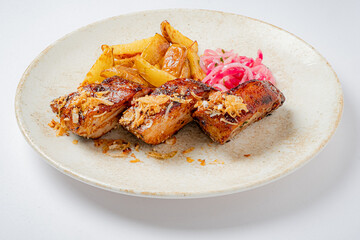 Enjoy grilled pork, golden potatoes, and pickled onions—culinary artistry on a plate!