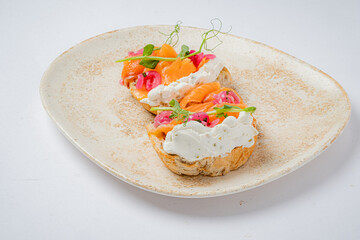 An open-faced sandwich with smoked salmon, cream cheese, and vibrant toppings, ideal for brunch
