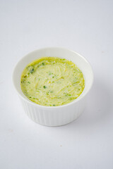 Herb-infused butter awaits in a white bowl, ready to enhance any meal with fresh flavors