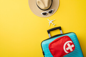 Travel preparation concept featuring colorful luggage, first aid kit, and summer hat against yellow