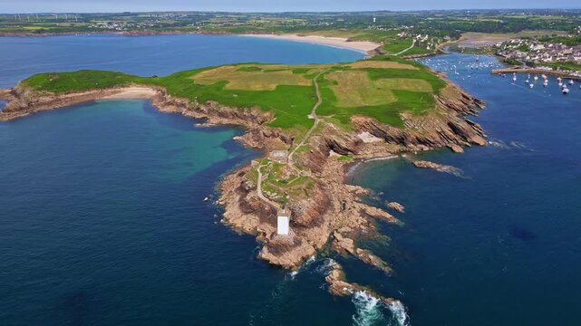 Kermorvan peninsula, historic fort, lighthouse, Le Conquet harbor, and Plage des Blancs Sablons beach in Brittany, France. Aerial forward