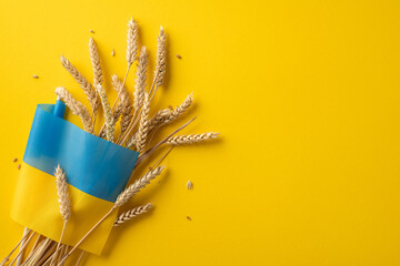 Golden wheat stems arranged with a flag design, set against a bright yellow background capturing...