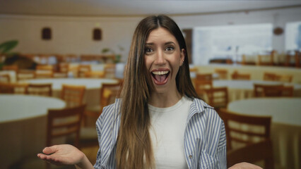 Woman with open palm gesture and open mouth expression in a brightly lit restaurant setting;...
