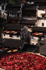 Harvest season in a Chinese village showcases traditional architecture and vibrant red chilies