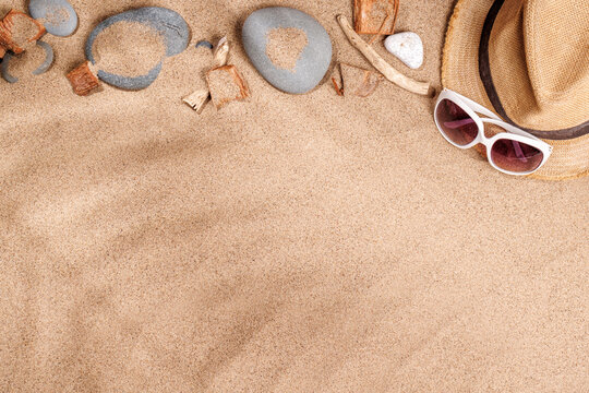 A tropical summer background featuring soft beach sand with delicate palm leaf shadows and sunhat