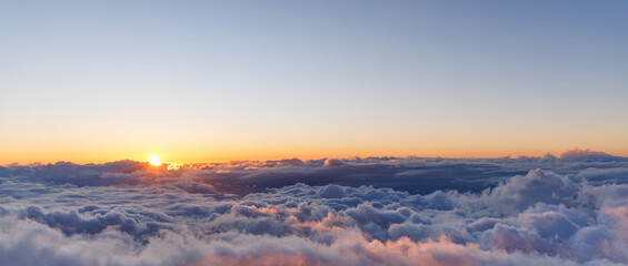 Sunset above the clouds with warm colors and soft light