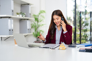 Confident asian business woman, broker real estate agent or manager, sitting at table in a modern...