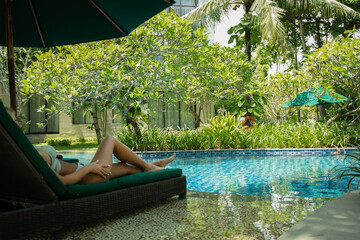 Woman relaxes by the peaceful pool in lush greenery