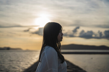 夕日の海にいる女性