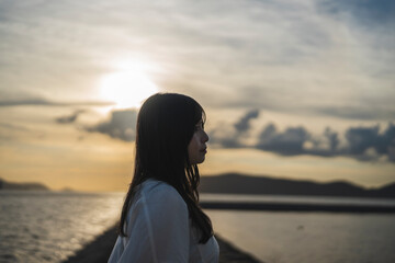 夕日の海にいる女性