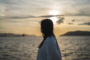 夕日の海にいる女性