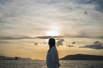 夕日の海にいる女性