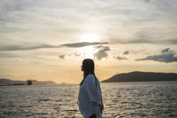 夕日の海にいる女性