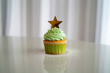 Delightful cupcake topped with vibrant green frosting and a golden star, perfect for celebrations and sweet moments