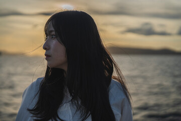 夕日の海にいる女性