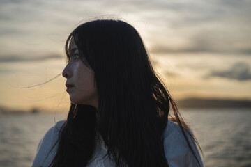 夕日の海にいる女性