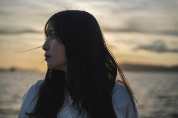 夕日の海にいる女性