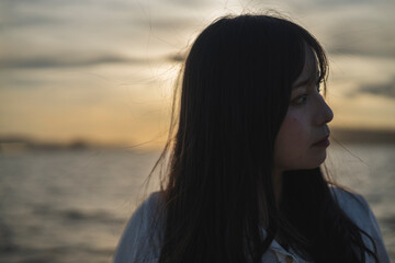 夕日の海にいる女性