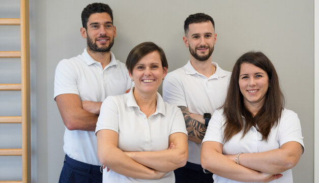 Friendly physiotherapy team standing together in a modern medical office - Powered by Adobe