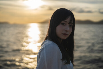 夕日の海にいる女性