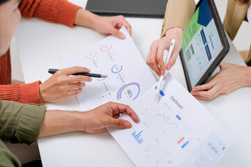 asian financial advisor presenting charts and data on a tablet during couple client meeting.financial planning and decision-making