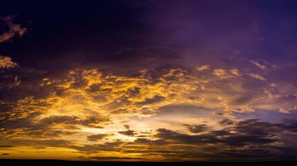 Dramatic sunrise with gradient orange and purple clouds, creating a panoramic abstract sky view.